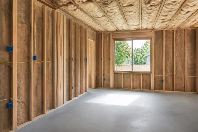 Insulated framed walls and rough electrical work inside a garage conversion.