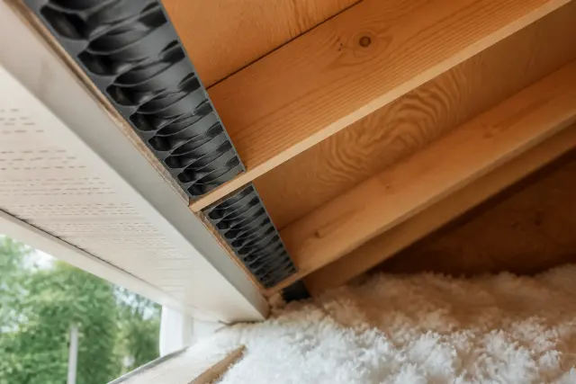 Attic baffles preserving airflow above insulation at the soffit.